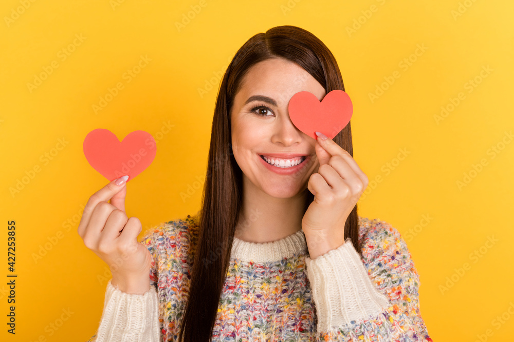 Photo of attractive happy lovely young lady hold hands heart shape cover eye isolated on shine yellow color background Photo of attractive happy lovely young lady hold hands heart shape cover eye isolated on shine yellow color background