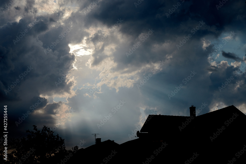 A picture of dramatic clouds over house silhouettes in a village. Taken in Sweden 2020.