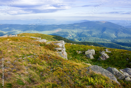 landscape of carpathian mountains. stones on the hill. view in to the distant valley. clouds on the sky in morning light. wonderful travel destination