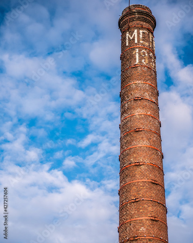 Old bricks factory chimney with bricks. blue sky background. color