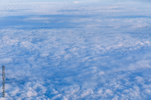 Above clouds, view from pilot cabin in airplane. Aerial view abo