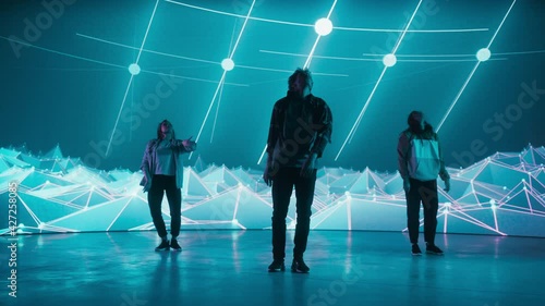 Diverse Group of Three Professional Dancers Performing a Hip Hop Dance Routine in Front of a Big Led Wall Screen with VFX Animation During a Virtual Production in Studio Environment
