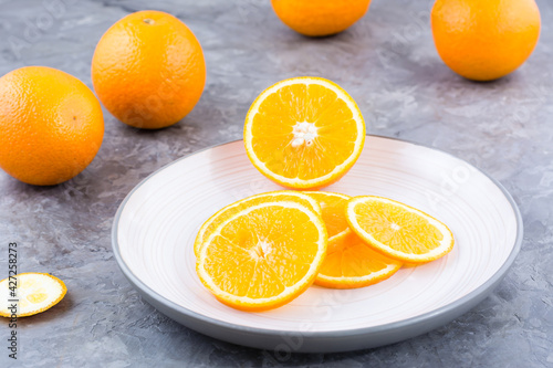 Pieces of fresh orange on a plate on the table. Vitamins, diet and vigor