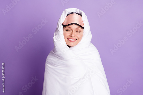 Photo portrait of dreamy lazy woman in white blanket smiling in the morning isolated on pastel violet color background