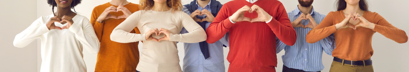 Group of thankful youth and senior citizens showing love and support and sending gratitude. Banner with midsection shot of young and mature people doing heart shape hand gesture