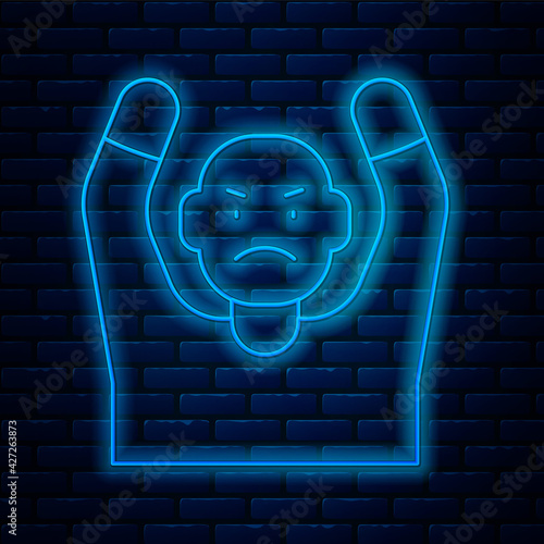 Glowing neon line Thief surrendering hands up icon isolated on brick wall background. Man surrendering with both hands raised in air. Vector