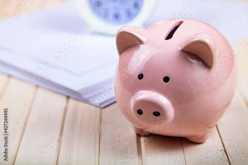 Pig piggy bank, paper and clock
