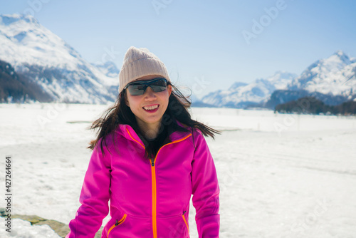 winter outdoors lifestyle portrait of young happy and attractive Asian Korean woman enjoying playful on snow at beautiful alpine mountain during Christmas holiday