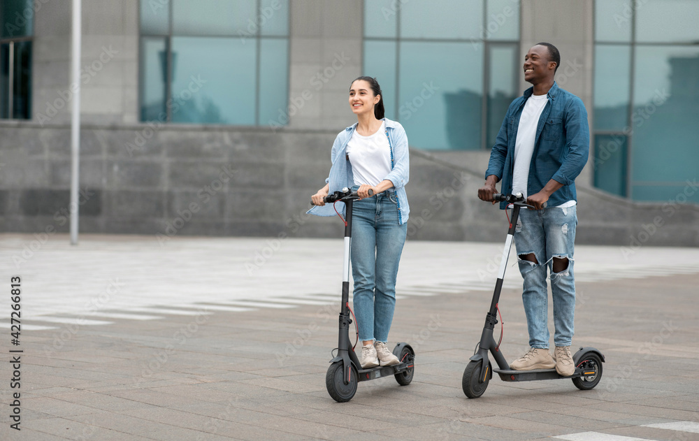 Black guy and lady having ride on electric kick scooter Black guy and lady having ride on electric kick scooter
