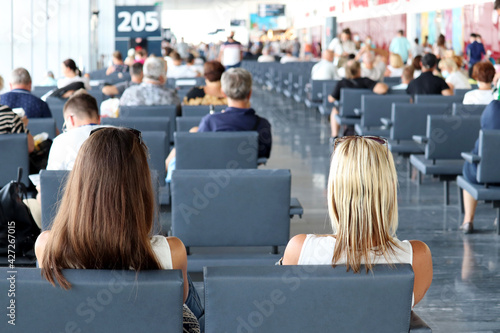 Passengers sitting in the airport terminal. People are waiting for their flight, travel concept