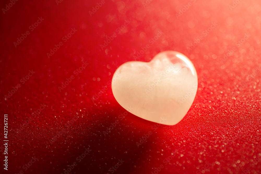 Heart shaped white stone on contrast red background. Copy space, close up; concept of pure love and feelings. Heart shaped white stone on contrast red background. Copy space, close up; concept of pure love and feelings.
