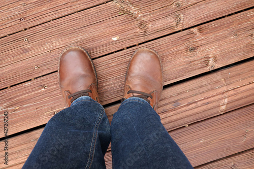 Feet in red shoes on a red wood floor