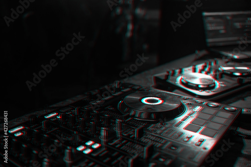 DJ console for mixing music with blurry people dancing at a nightclub party. Black and white with 3D glitch virtual reality effect