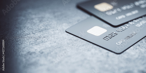 Online payments concept with black credit cards on abstract blank dark surface, 3D rendering, mock up photo
