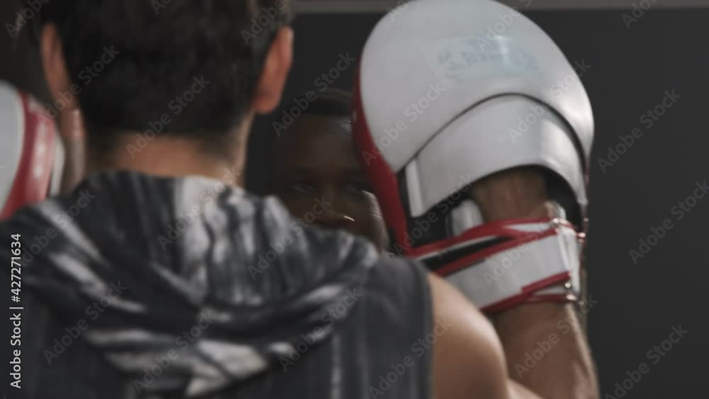 Black man practicing boxing with a trainer in the gym. Black man practicing boxing with a trainer in the gym.