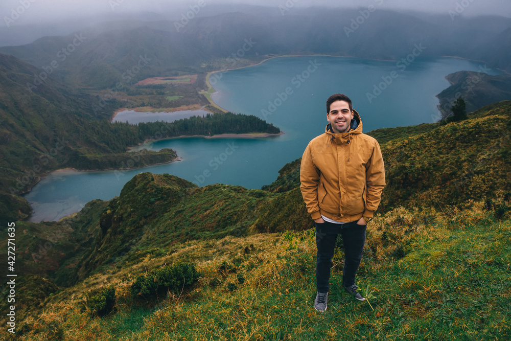 Aerial view. A man smiles on the top of the island against the backdrop of a beautiful lake. Azores.