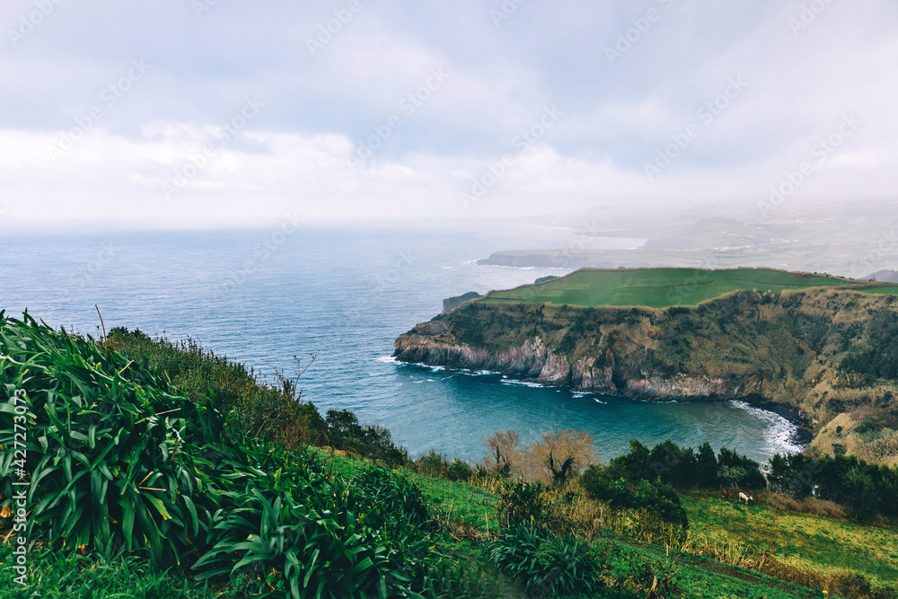 Lonely beautiful viewpoint overlooking the sea and the lush nature of the Azores. Lonely beautiful viewpoint overlooking the sea and the lush nature of the Azores.