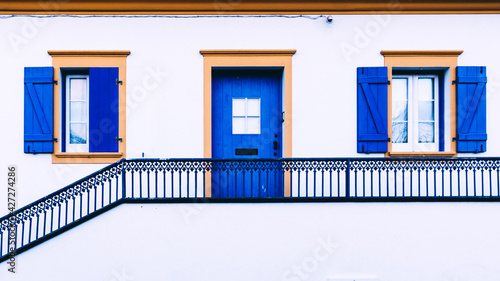 A beautiful house with a blue door and windows. A country house.