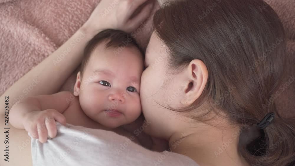 asian woman mother parent sleeping with baby infant. sleepy baby yawning in mother arm. asian woman mother parent sleeping with baby infant. sleepy baby yawning in mother arm.