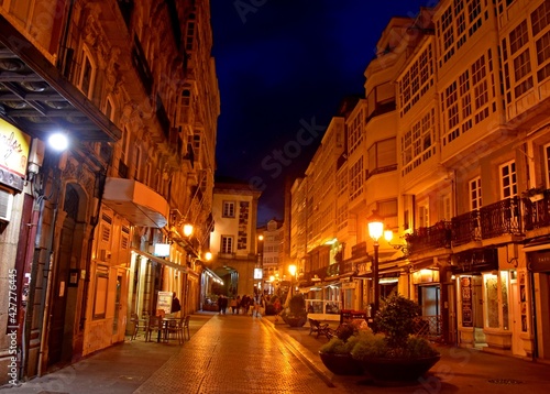 Imagen nocturna de una calle peatonal en verano con la atmósfera cálida que le confiere la iluminación artificial