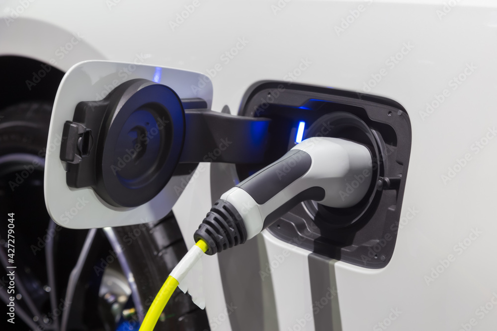 Electric vehicle at charging station with plugged in, Eco-friendly alternative energy concep Electric vehicle at charging station with plugged in, Eco-friendly alternative energy concep