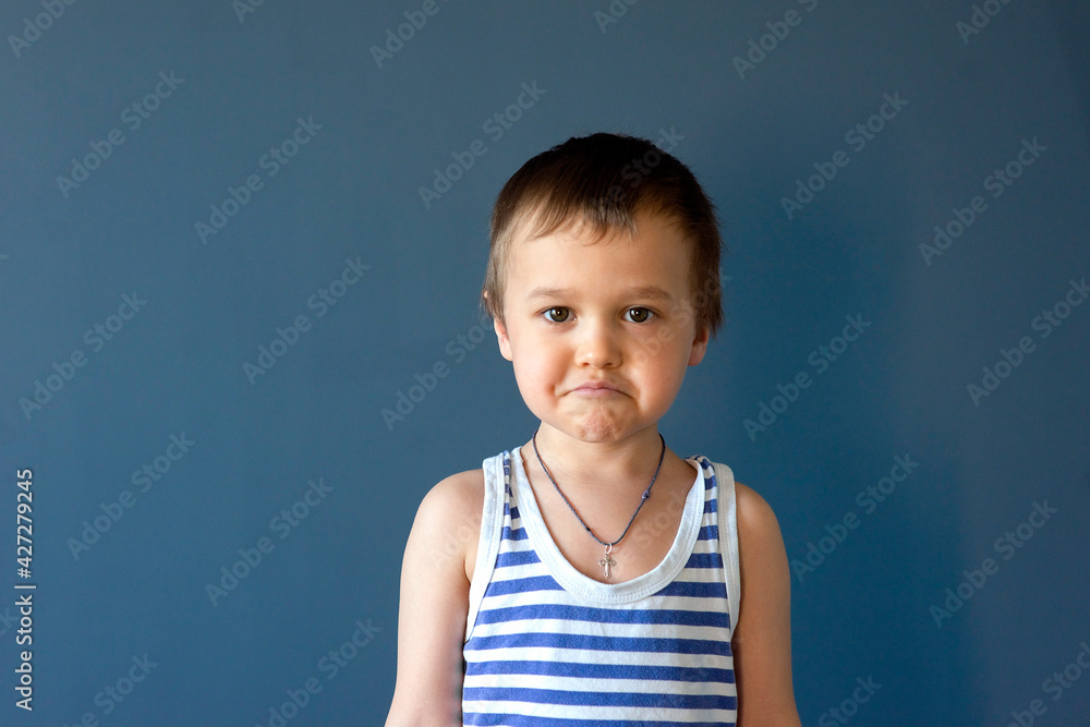 Happy child. Portrait of a beautiful boy in a vest, smiling, isolated on a blue background. selective focus Happy child. Portrait of a beautiful boy in a vest, smiling, isolated on a blue background. selective focus