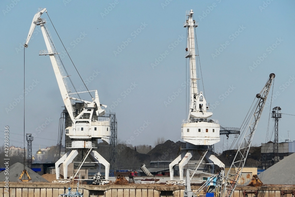 River port. The factory by the river. Sand mining. A crane and special equipment for loading sand. High quality photo