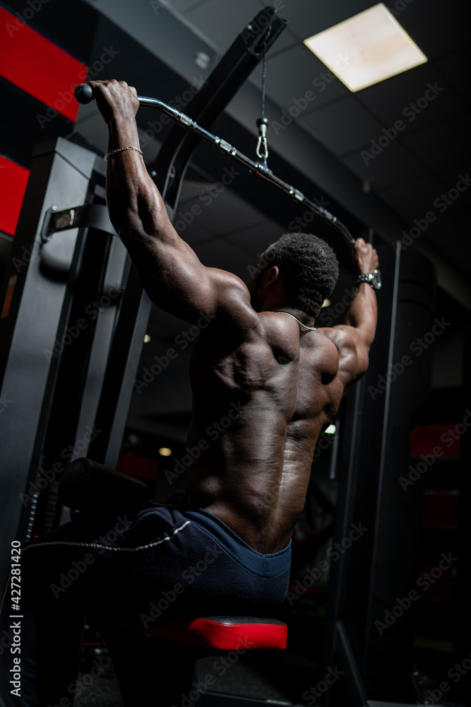 Athlete man doing back exercises. African athlete in the gym. Athlete man doing back exercises. African athlete in the gym.