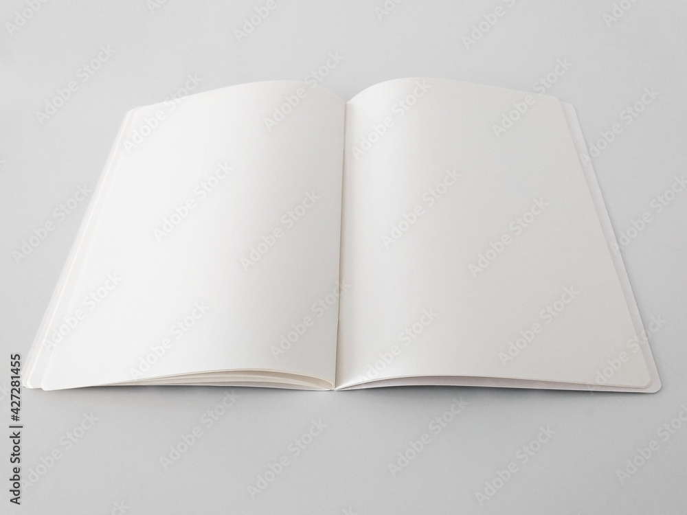 Perspective view of open and blank notepad isolated on white background. Aerial view of notebook to write made with sustainable paper. Stationery and writing concept. Perspective view of open and blank notepad isolated on white background. Aerial view of notebook to write made with sustainable paper. Stationery and writing concept.