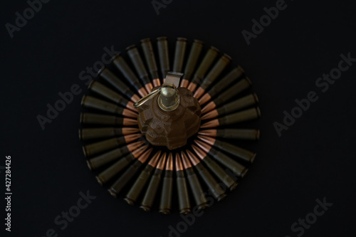 Grenade and cartridges for AKM 7.62x39 in the form of a circle on a black background photo
