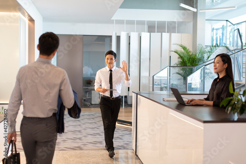 Cheerful business people greeting in office photo