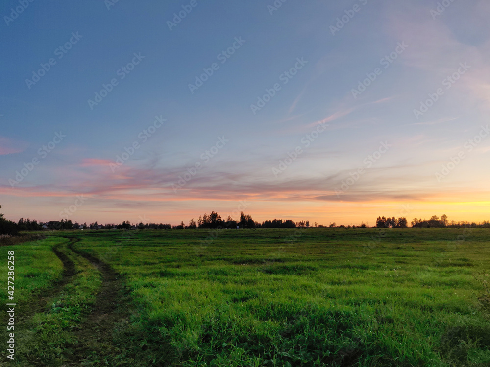 Sunset over the field. Golden sky. Bright sky.