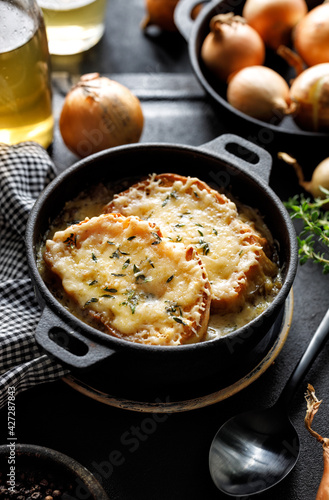 Onion soup with cheese croutons in a cast iron dish, a traditional dish of French cuisine