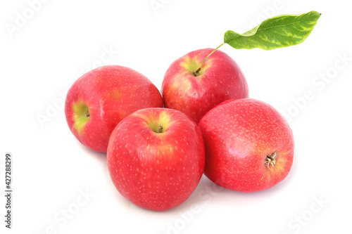 Four ripe red apples with leaf isolated on white