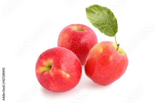 Three ripe red apples with leaf isolated on white