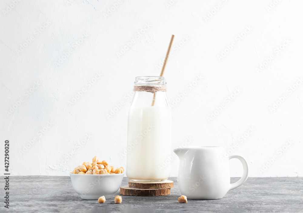 Alternative vegan milk of chickpeas in glass bottle with eco friendly straw on white background Alternative vegan milk of chickpeas in glass bottle with eco friendly straw on white background