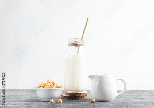 Alternative vegan milk of chickpeas in glass bottle with eco friendly straw on white background