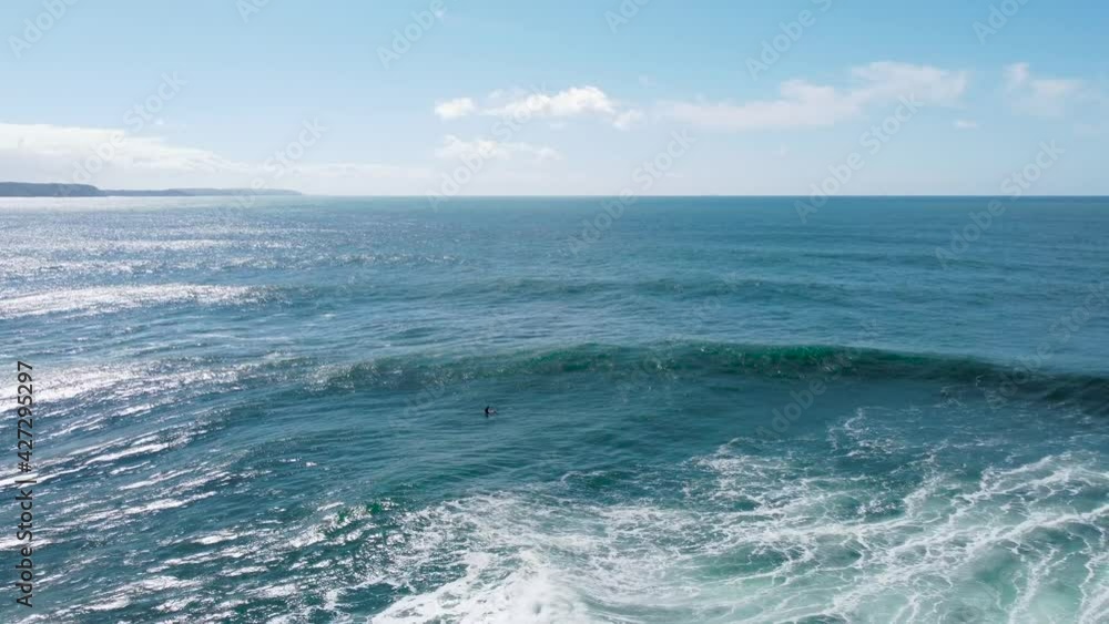 4k drone shot, surfer drifting in the middle of the ocean, in blue water, on a red surfboard, trying to catch a good wave 4k drone shot, surfer drifting in the middle of the ocean, in blue water, on a red surfboard, trying to catch a good wave
