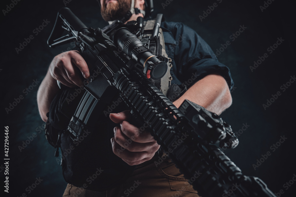 Fototapeta premium Special forces soldier with contemporary rifle in dark background