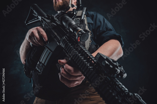 Special forces soldier with contemporary rifle in dark background