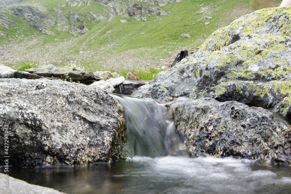 Wasser fließt über Steine einen Bergbach hinunter Wasser fließt über Steine einen Bergbach hinunter