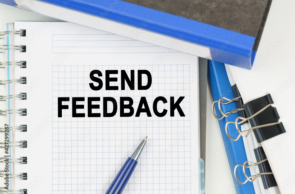 Among the documents, folders, a notebook with the inscription - SEND FEEDBACK Among the documents, folders, a notebook with the inscription - SEND FEEDBACK