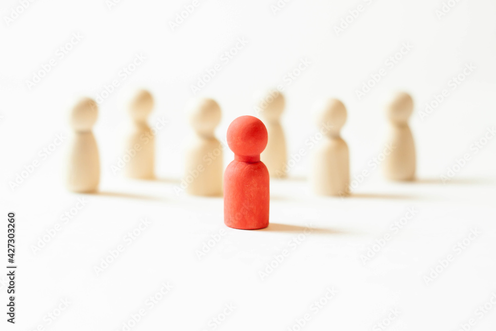 Red figurine of a man in a crowd of people. Infected carrier of the threat of the spread of a pandemic. Social distance. Experiences the head trains the business team. Red figurine of a man in a crowd of people. Infected carrier of the threat of the spread of a pandemic. Social distance. Experiences the head trains the business team.