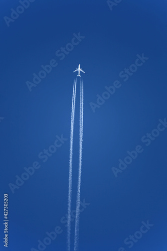 Jet trail from airplane travelling over clear blue sky