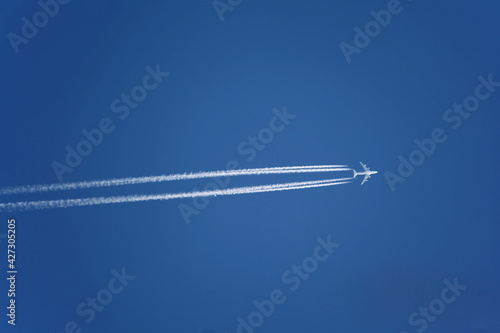 Jet steam from airplane travelling over clear blue sky