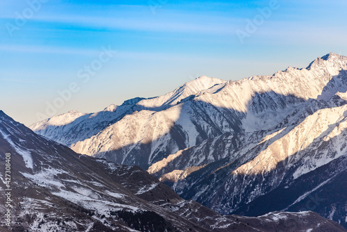 Elbrus region in the sunlight. A large valley among the steep Caucasus mountains.