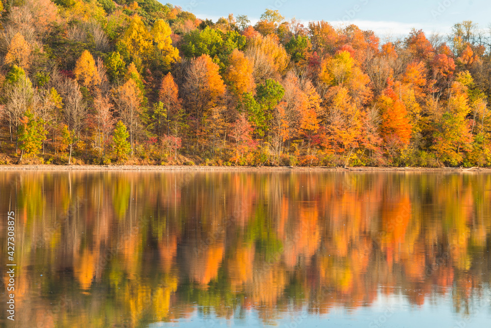 reflection of vibrant colorful peak autumn foliage of trees in the  serene Lake Habeeb in Rocky Gap State Park in Western Maryland Allegany county.