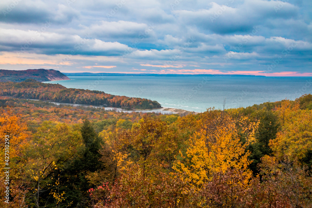 colorful autumn foliage in the Sleeping Bear Sand Dunes National Lakeshore overlooking dramatic sunset  in Michigan Lake.