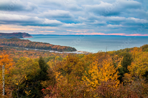 colorful autumn foliage in the Sleeping Bear Sand Dunes National Lakeshore overlooking dramatic sunset in Michigan Lake.