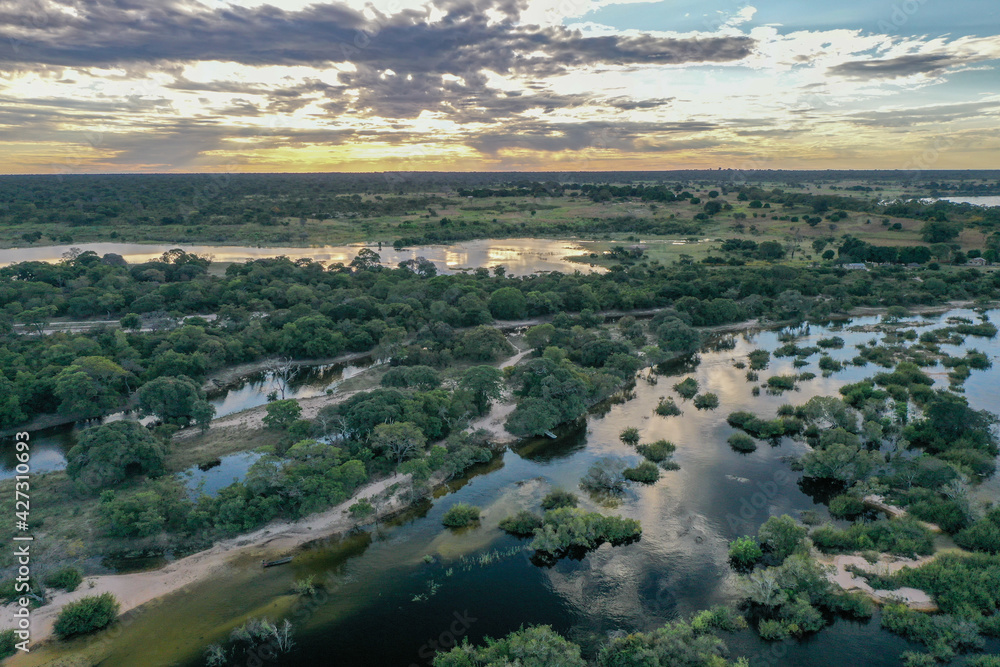 Wide aerial view of the Zambezi river in Zambia in flood with sunset in the background.